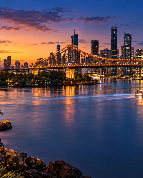 Brisbane city lit up at twilight above the river